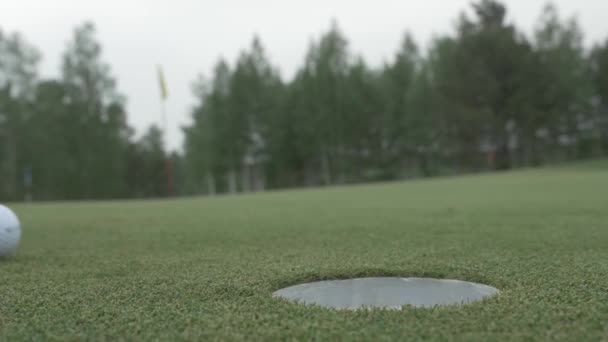 球滚进洞里。要掉进一个洞的高尔夫球场球。高