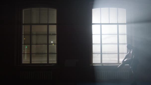 纵向运动男子哪站附近健身房中的窗口。站在窗